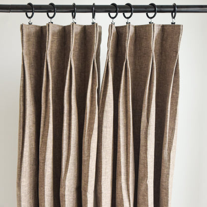Brown striped curtain hanging on a rod against a white background