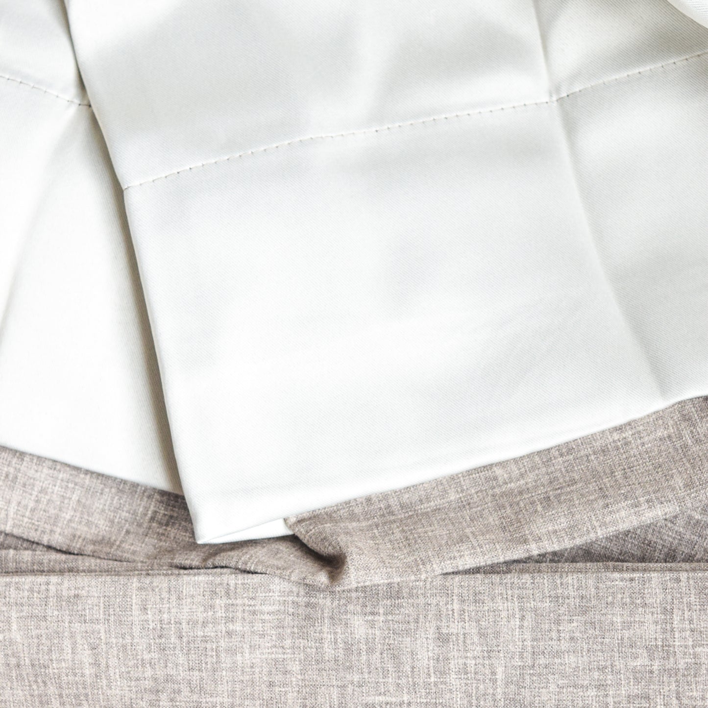 Close-up of white fabric sheets on a textured gray surface