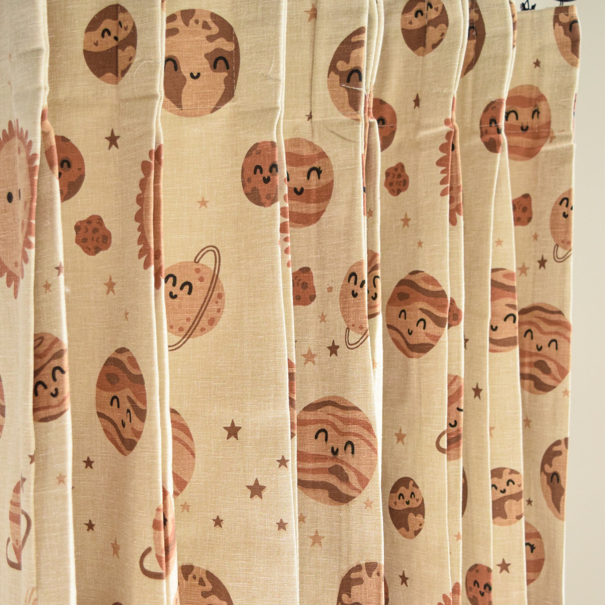 Sheer curtain with planet-themed pattern on a beige background