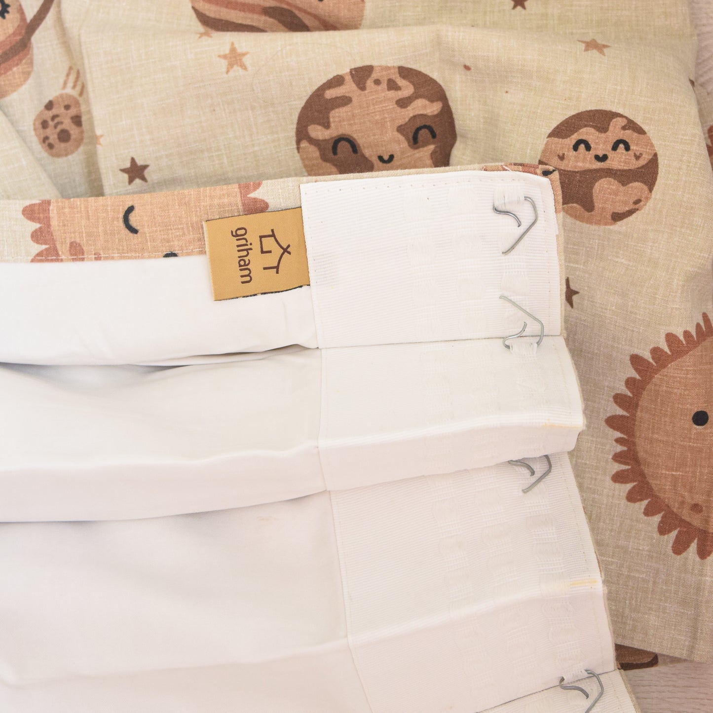 Folded white fabric with a cartoon character pattern and a visible brand tag.