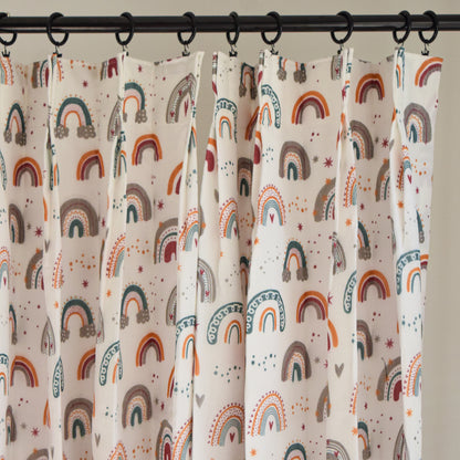 Curtains with rainbow pattern hanging on a rod against a neutral background
