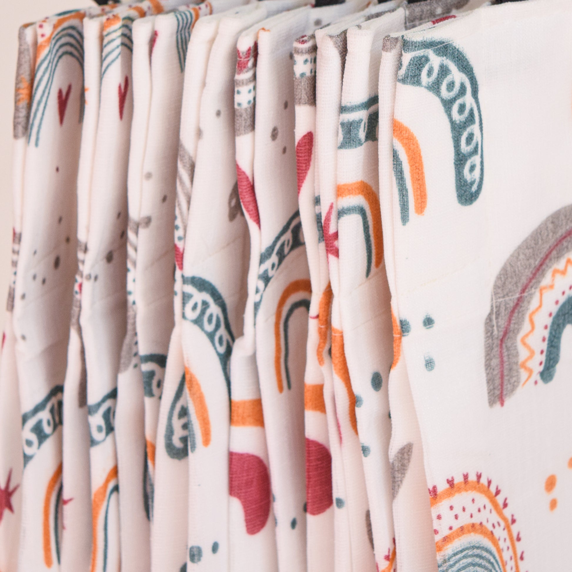 Row of folded fabric swatches with various patterns on a neutral background