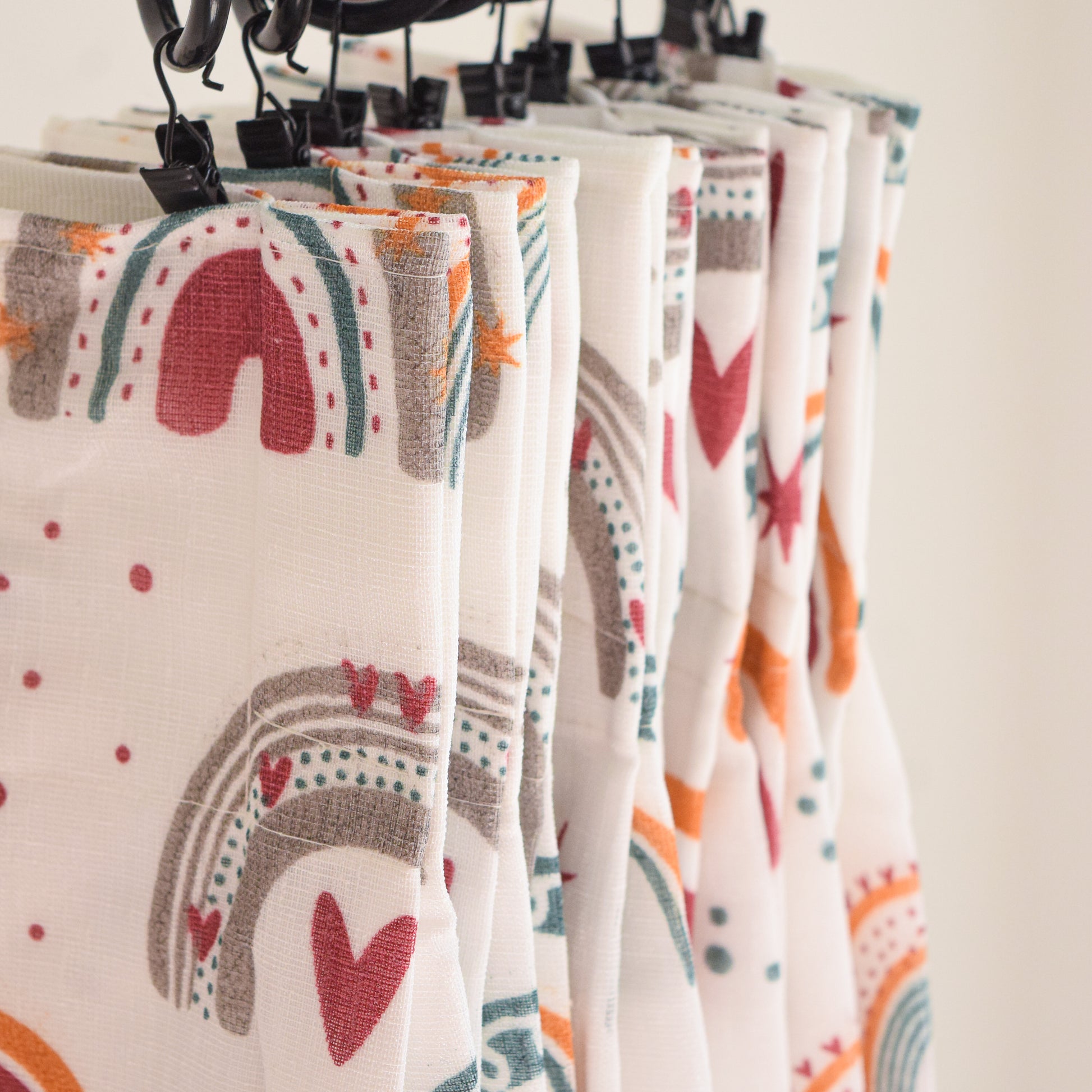 Patterned curtain hanging on a rack with a neutral background