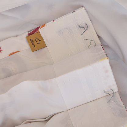 Close-up of a beige fabric with embroidered designs and a visible brand label.