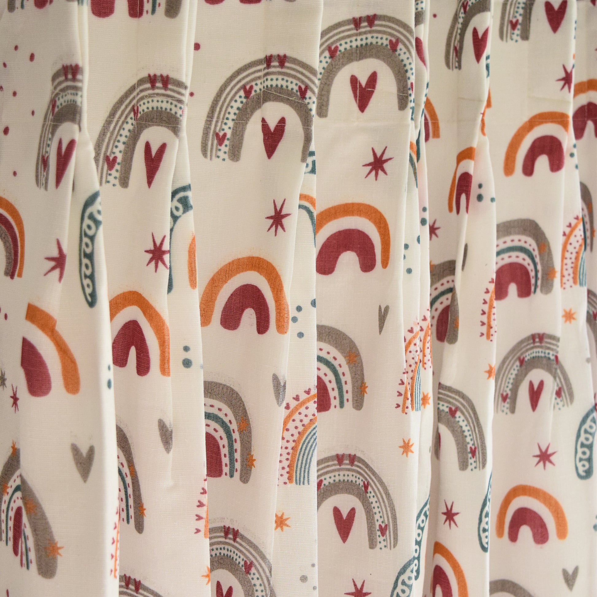 Curtain with colorful rainbow and heart pattern on a beige background
