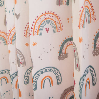 Patterned fabric with colorful rainbows and hearts on a light background