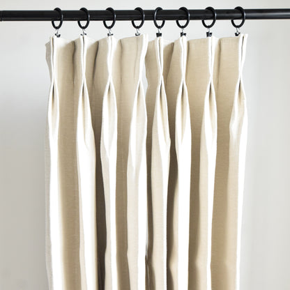 Beige curtains hanging from a rod against a white background