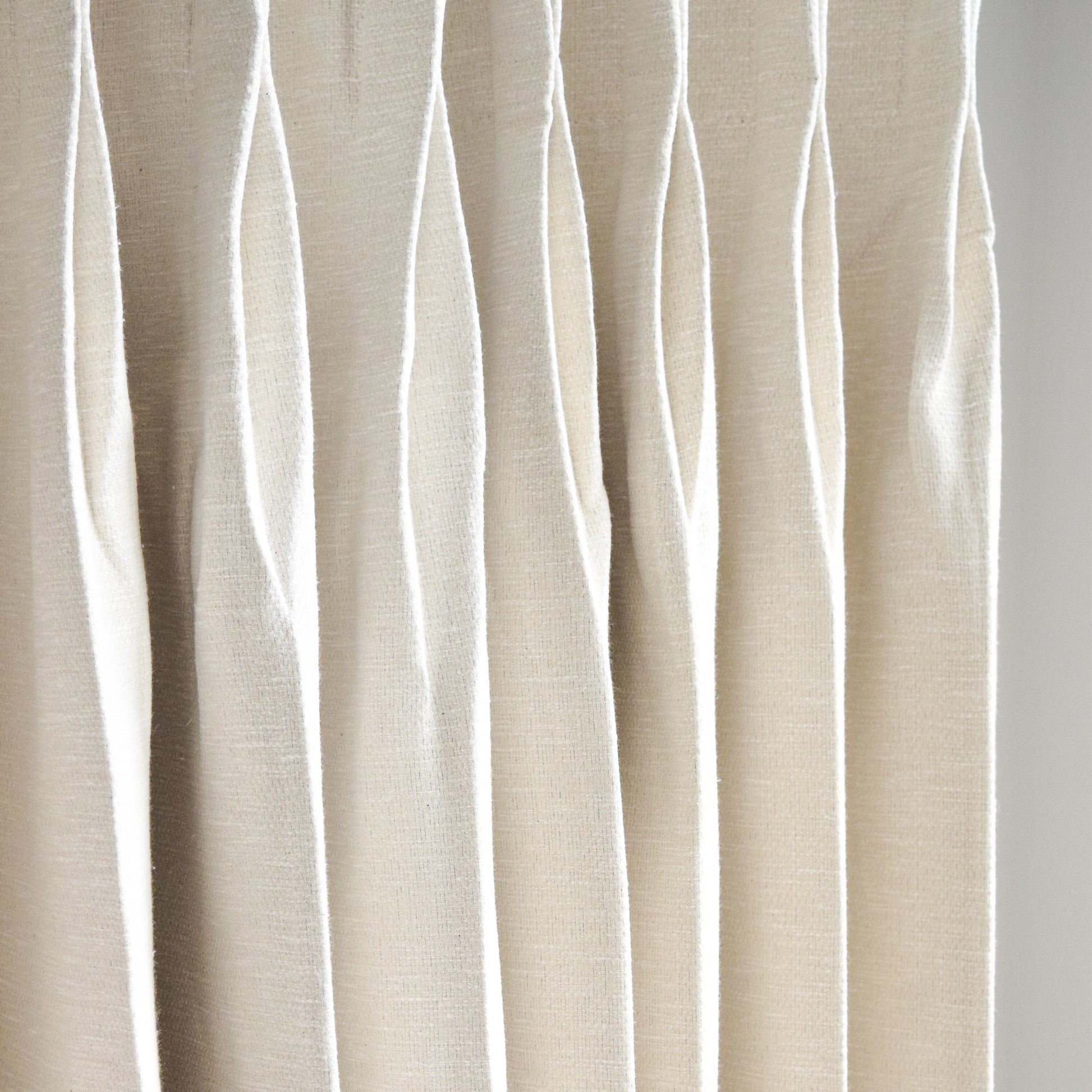 Beige curtain with wavy pattern on a white background