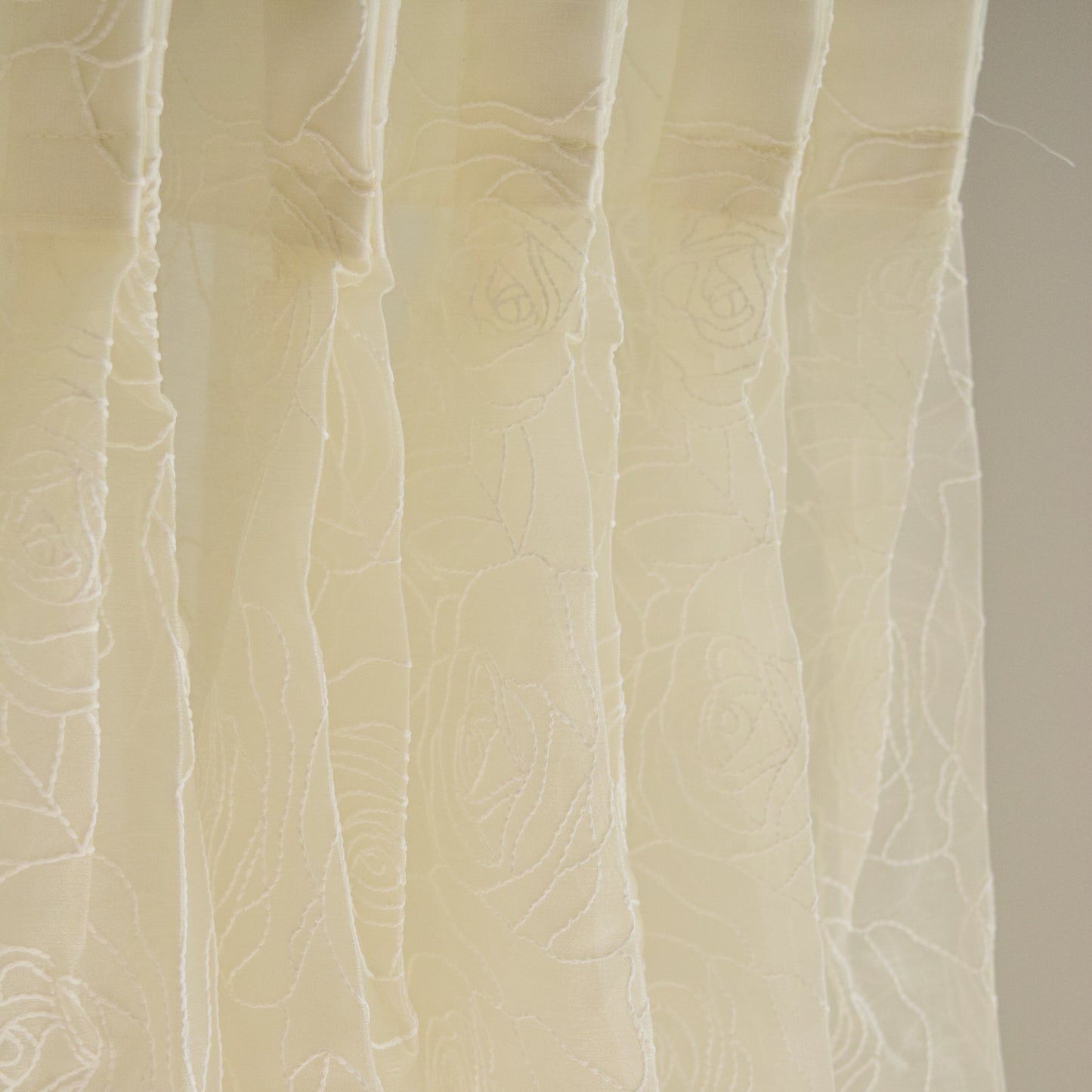 Close-up of textured beige fabric curtain with a subtle pattern