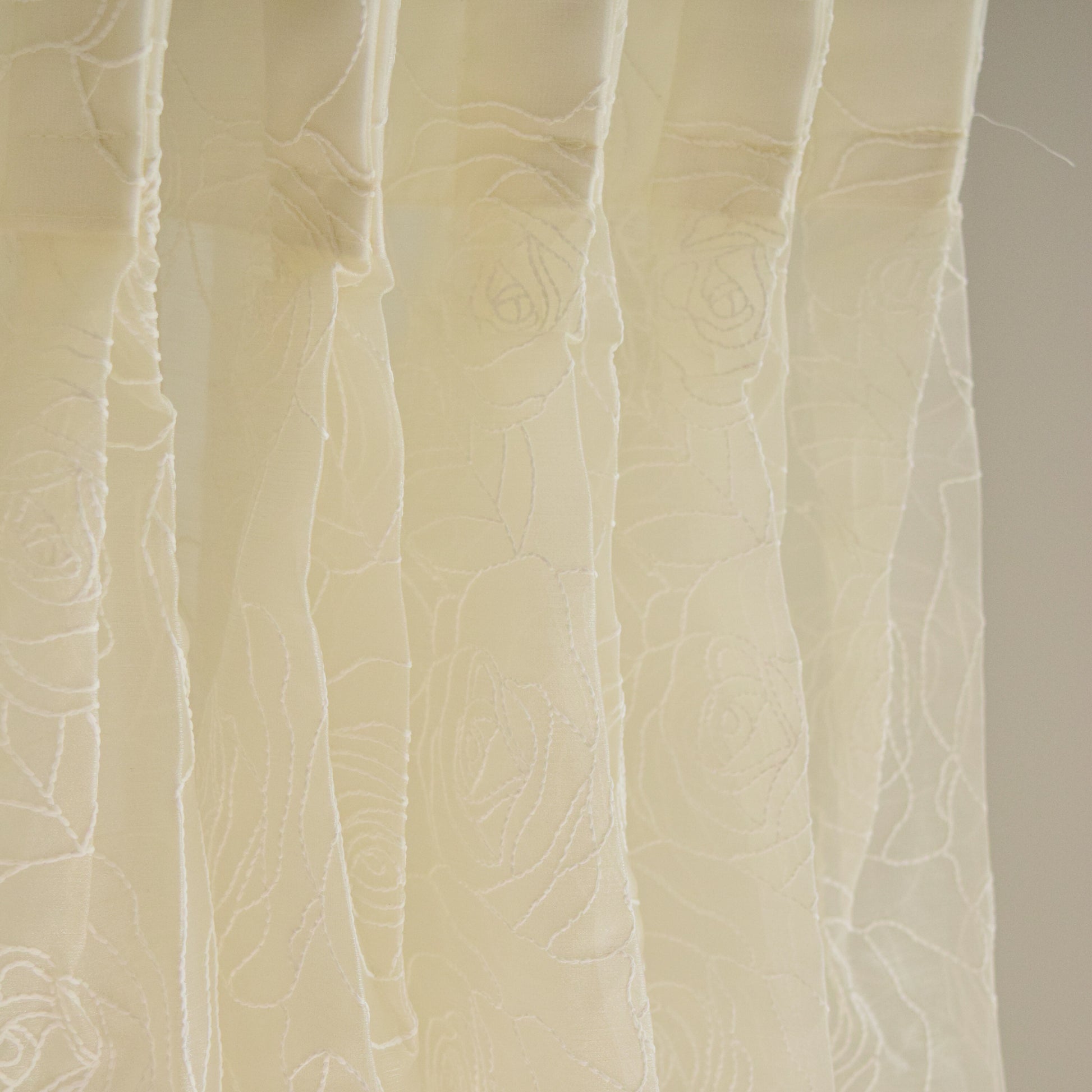 Close-up of textured beige fabric curtain with a subtle pattern