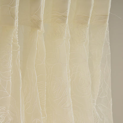 Close-up of textured beige fabric curtain with a subtle pattern