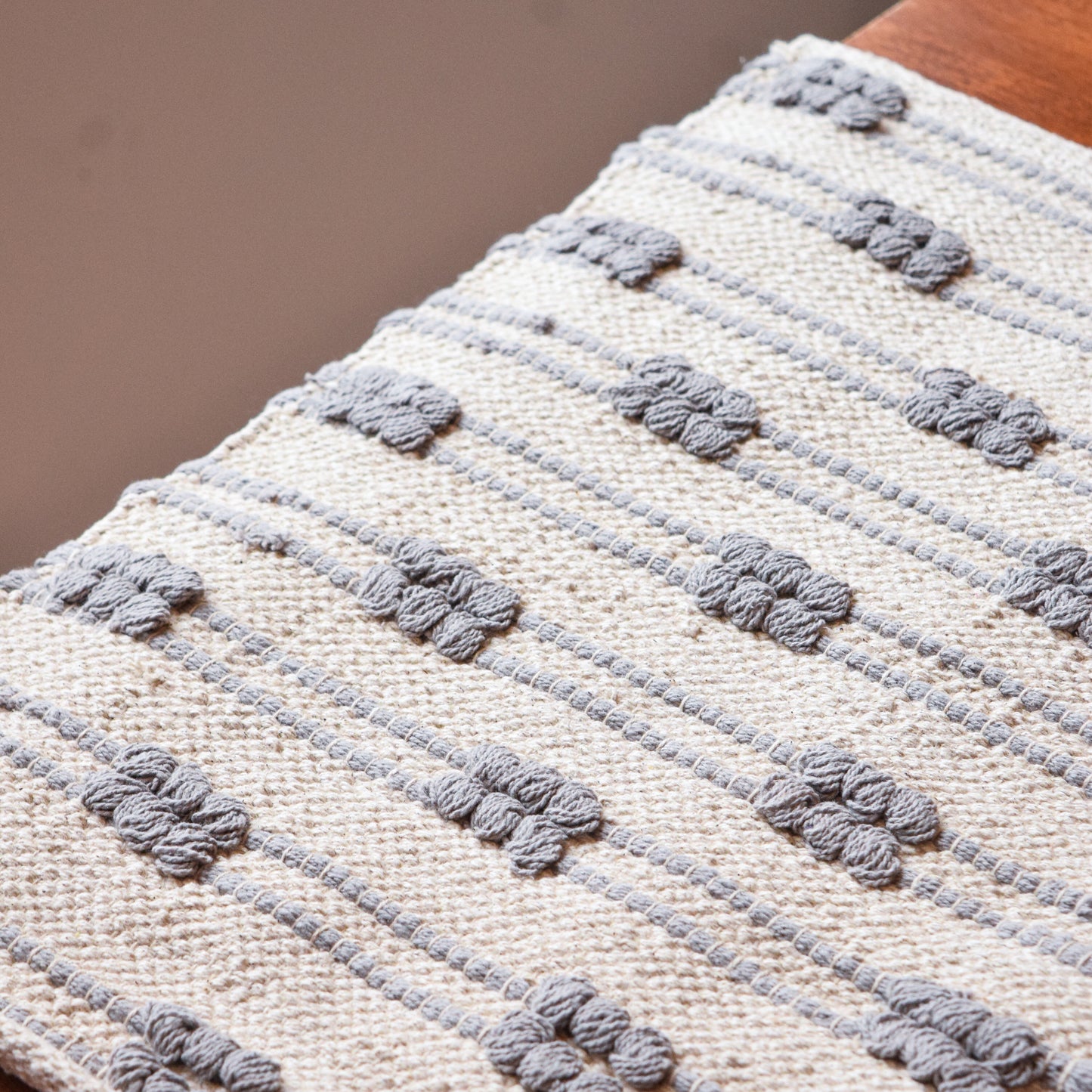 Close-up of a textured fabric with floral patterns on a neutral background