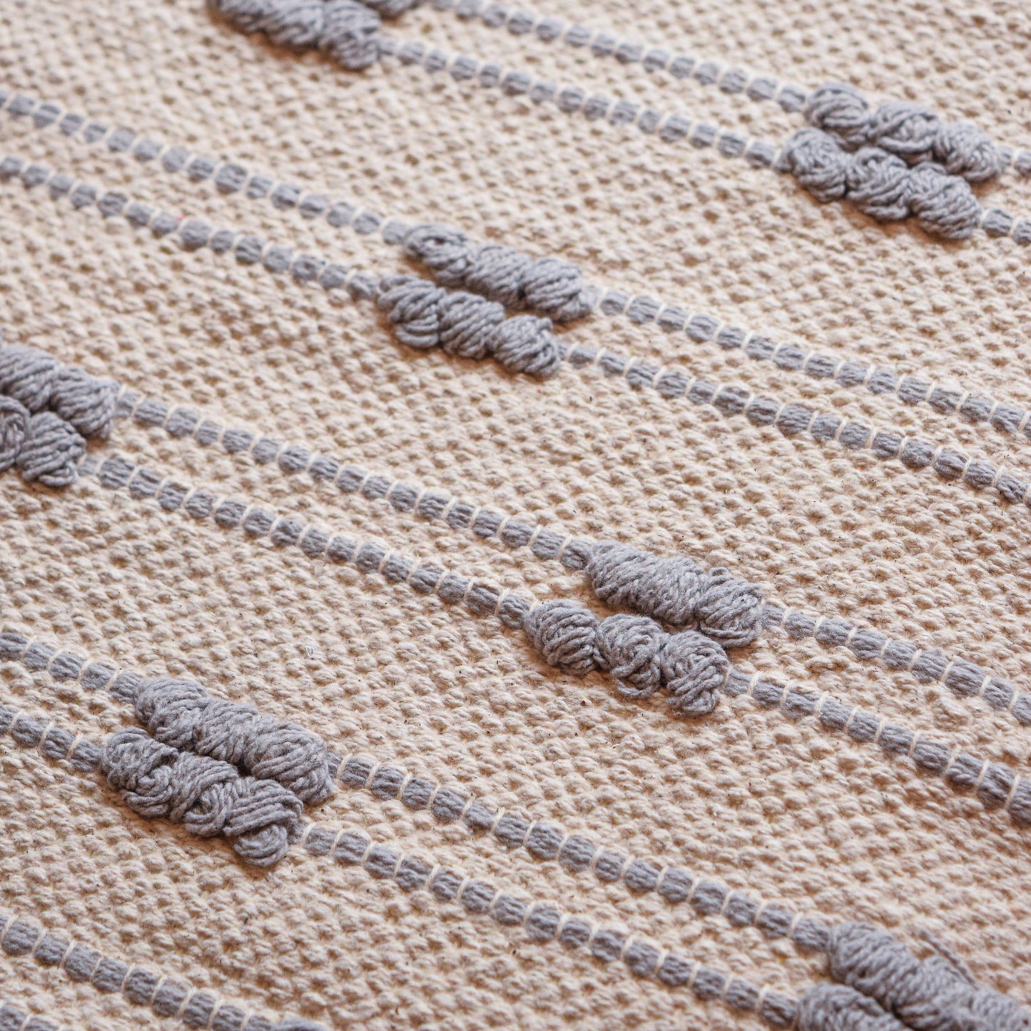 Textured fabric with knotted threads on a beige background