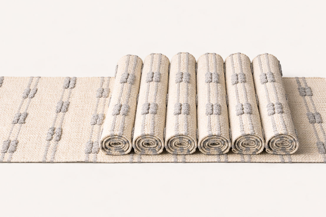 Set of rolled-up rugs with a geometric pattern on a white background