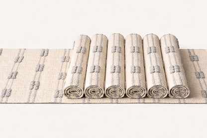 Set of rolled-up rugs with a geometric pattern on a white background