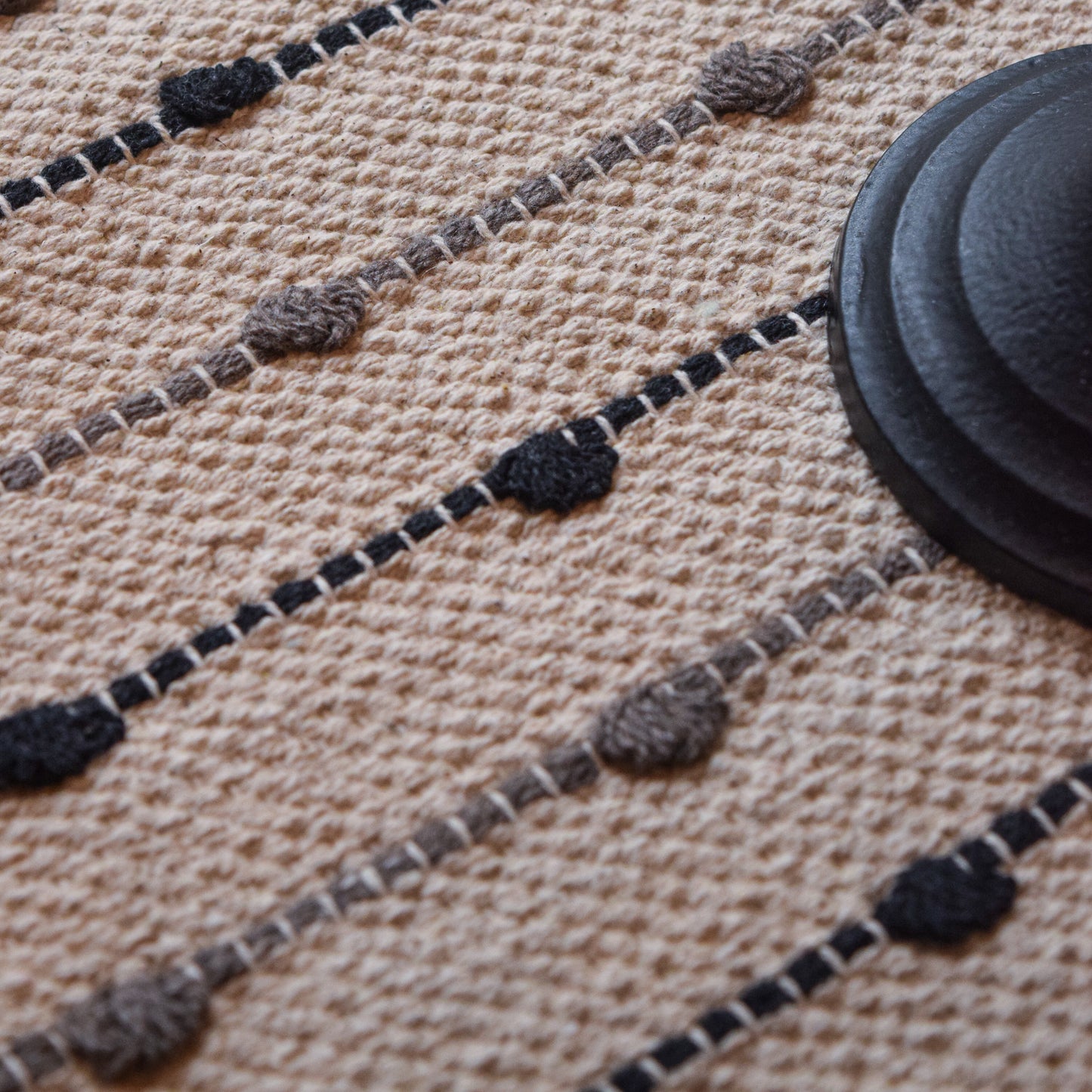 Close-up of a textured rug with black and gray patterns