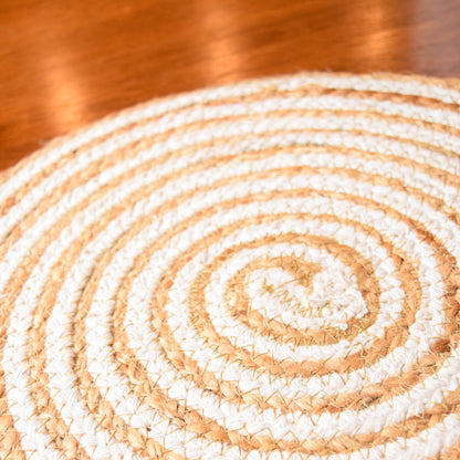 Close-up of a woven circular mat with concentric circles on a wooden surface.