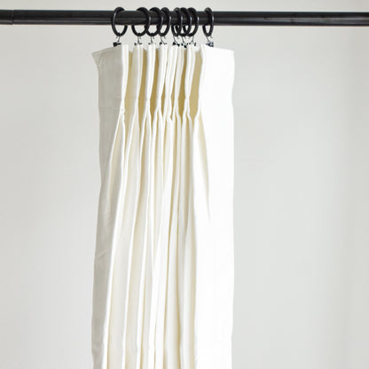 White curtains hanging from a rod against a plain background